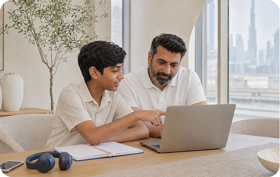A parent and teenager looking at a laptop together
